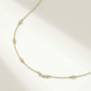 Collier Ana de OPALINE PARIS avec pendentif délicat en or et perles, posé sur un fond neutre.