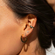 Earcuff Vera d'OPALINE PARIS, ornement en métal argenté avec détails élégants, porté sur une oreille.